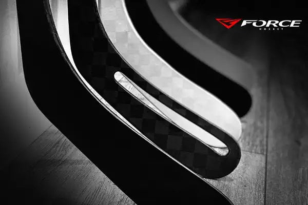 Photo en noir et blanc montrant les palettes et courbes des bâtons de hockey Prototype All Black et le logo Force Hockey en coin.